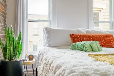 a bedroom with a bed with a plant and a window at Bamboo Bungalow by Jungle House Near Convention Center OSU & Nationwide Arena Walk to High Street Downtown & Short North 5 800 Reviews Private Parking in Columbus