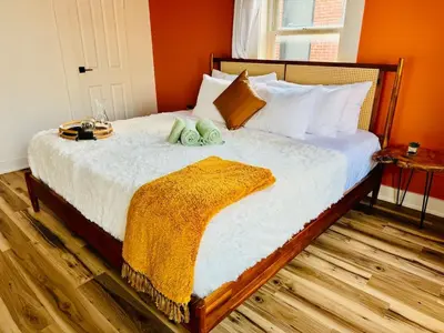 a bedroom with a large bed with orange walls at Cozy Casita by Jungle House Downtown & Short North Free Parking 5 800 Reviews Near Convention Center & Nationwide Arena & Ohio State Walk to High Street in Columbus