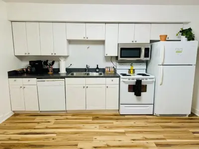a kitchen with white cabinets and a white refrigerator at Cozy Casita by Jungle House Downtown & Short North Free Parking 5 800 Reviews Near Convention Center & Nationwide Arena & Ohio State Walk to High Street in Columbus