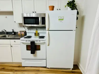 a kitchen with a white refrigerator and a microwave at Cozy Casita by Jungle House Downtown & Short North Free Parking 5 800 Reviews Near Convention Center & Nationwide Arena & Ohio State Walk to High Street in Columbus
