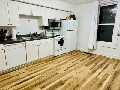 a kitchen with white cabinets and a wooden floor at Cozy Casita by Jungle House Downtown & Short North Free Parking 5 800 Reviews Near Convention Center & Nationwide Arena & Ohio State Walk to High Street in Columbus