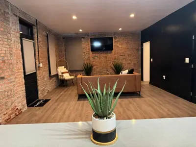 a living room with a couch and a potted plant at Jungle Vibe by Jungle House Downtown & Short North Free Parking 5 800 Reviews Near Convention Center & Nationwide Arena & Ohio State Walk to High Street in Columbus
