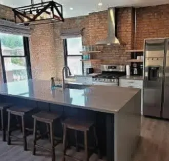 a kitchen with a large island with bar stools at Jungle Vibe by Jungle House Downtown & Short North Free Parking 5 800 Reviews Near Convention Center & Nationwide Arena & Ohio State Walk to High Street in Columbus