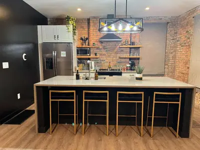 a kitchen with a large island with bar stools at Jungle Vibe by Jungle House Downtown & Short North Free Parking 5 800 Reviews Near Convention Center & Nationwide Arena & Ohio State Walk to High Street in Columbus