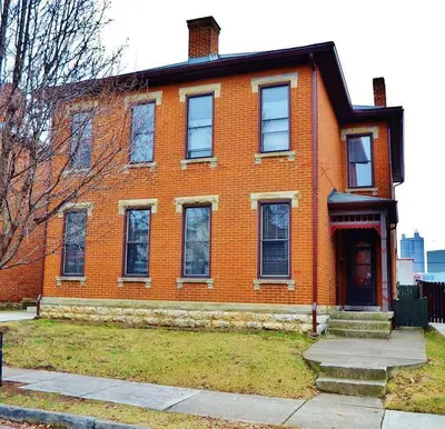 an orange brick house with a red door on a street at Jungle Vibe by Jungle House Downtown & Short North Free Parking 5 800 Reviews Near Convention Center & Nationwide Arena & Ohio State Walk to High Street in Columbus