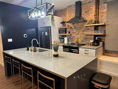 a kitchen with a large white island in a room at Jungle Vibe by Jungle House Downtown & Short North Free Parking 5 800 Reviews Near Convention Center & Nationwide Arena & Ohio State Walk to High Street in Columbus