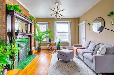 a living room with a couch and a fireplace at Jungle Book by Jungle House Walkable to High Street Downtown & Short North Near Nationwide Arena OSU & Convention Center Free Parking 5 800 Reviews in Columbus