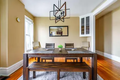 a dining room with a wooden table and chairs at Jungle Book by Jungle House Walkable to High Street Downtown & Short North Near Nationwide Arena OSU & Convention Center Free Parking 5 800 Reviews in Columbus