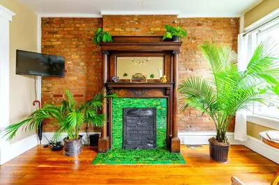 a brick fireplace with plants in a living room at Jungle Book by Jungle House Walkable to High Street Downtown & Short North Near Nationwide Arena OSU & Convention Center Free Parking 5 800 Reviews in Columbus