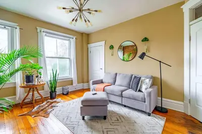 a living room with a couch and a mirror at Jungle Book by Jungle House Walkable to High Street Downtown & Short North Near Nationwide Arena OSU & Convention Center Free Parking 5 800 Reviews in Columbus