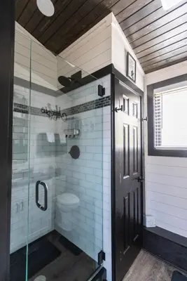 a bathroom with a shower with a glass door at Black Tie Affair - Eloquent Riverfront Experience in New Richmond