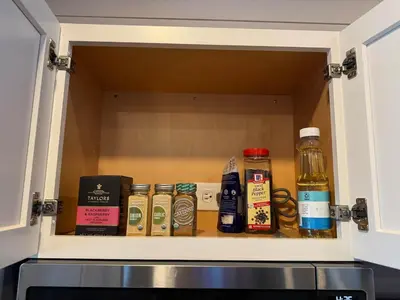 a cupboard filled with lots of bottles of spices at Black Tie Affair - Eloquent Riverfront Experience in New Richmond