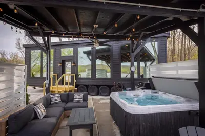 a large outdoor hot tub in the middle of a patio at Black Tie Affair - Eloquent Riverfront Experience in New Richmond