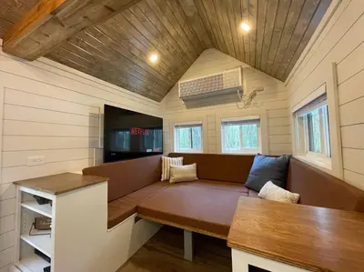 a living room with a couch in a tiny house at Stargazers' Retreat A Tiny Home on the Riverside in New Richmond