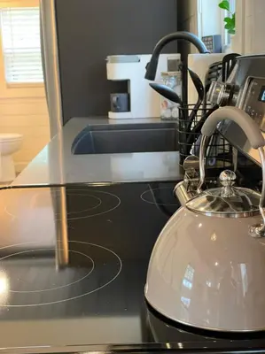 a kitchen counter with a tea kettle on a stove at Stargazers' Retreat A Tiny Home on the Riverside in New Richmond