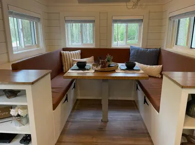 a dining room with a table and benches at Stargazers' Retreat A Tiny Home on the Riverside in New Richmond