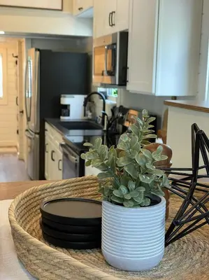 a kitchen with a table with a vase with a plant at Stargazers' Retreat A Tiny Home on the Riverside in New Richmond
