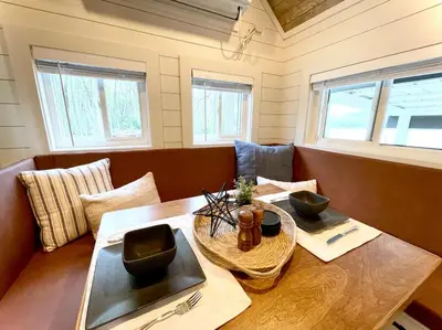 a dining room with a wooden table and chairs at Stargazers' Retreat A Tiny Home on the Riverside in New Richmond