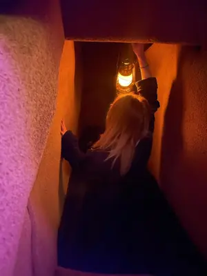 a woman reaching for a light in a dark room at GENIE ROMANCE SUITE with King Size Flying Carpet Bed, Jet Tub, Karaoke, Sultan's Foot Massage Room in Mount Vernon