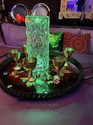 a glass vase sitting on a tray with wine glasses at GENIE ROMANCE SUITE with King Size Flying Carpet Bed, Jet Tub, Karaoke, Sultan's Foot Massage Room in Mount Vernon