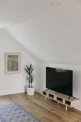 a living room with a flat screen tv on a table at “Ivory Inn” - Cozy Modern Stay w/ Hot Tub - LEX in Lexington