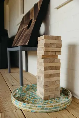 a stack of wooden blocks on a plate next to a table at “Ivory Inn” - Cozy Modern Stay w/ Hot Tub - LEX in Lexington
