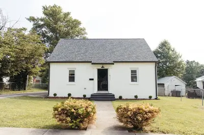 a white house with a black roof at “Ivory Inn” - Cozy Modern Stay w/ Hot Tub - LEX in Lexington