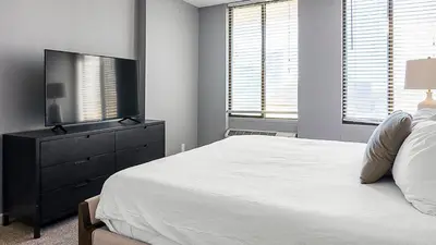 a bedroom with a bed and a flat screen tv at Landing Stunning Studio Game Room Pool in Fort Wayne