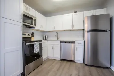 a kitchen with white cabinets and stainless steel appliances at Landing Stunning Studio Game Room Pool in Fort Wayne