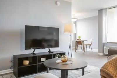 a living room with a flat screen tv on a wall at Landing Stunning Studio Game Room Pool in Fort Wayne