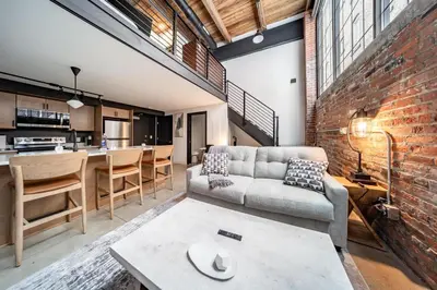 a living room with a couch and a brick wall at Landing Amazing 2BD Gym Courtyard in Cleveland