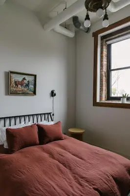 a bedroom with a red bed and a window at Hotel Royal in Toledo