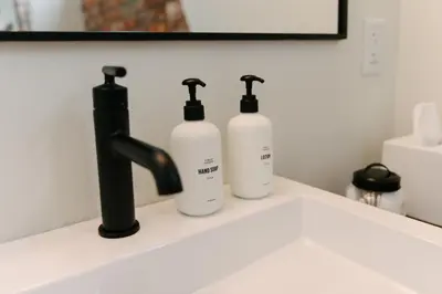 three bottles of soap are sitting on a bathroom sink at Hotel Royal in Toledo