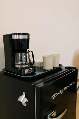 a coffee maker sitting on top of a black cabinet at Hotel Royal in Toledo