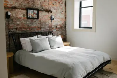 a bed in a room with a brick wall at Hotel Royal in Toledo