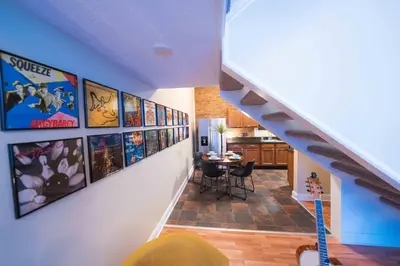 a room with a staircase with posters on the wall at Bright and Hip 2BR Condo in Heart of Ohio City in Cleveland