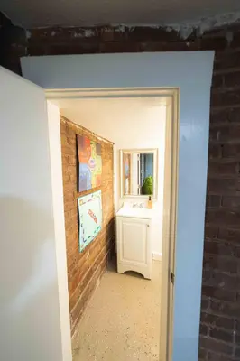 a bathroom with a sink and a brick wall at Bright and Hip 2BR Condo in Heart of Ohio City in Cleveland