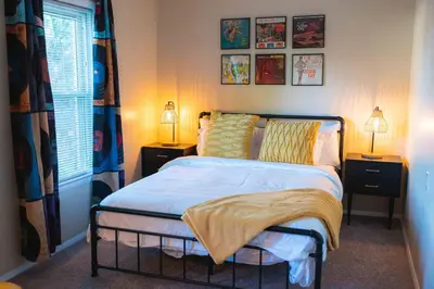a bedroom with a bed with two night stands and two lamps at Bright and Hip 2BR Condo in Heart of Ohio City in Cleveland