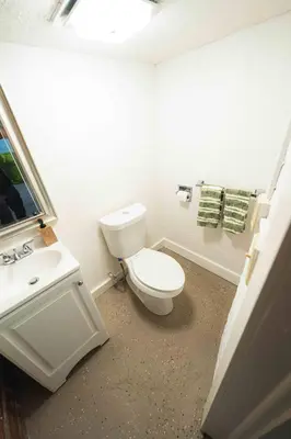 a bathroom with a white toilet and a sink at Bright and Hip 2BR Condo in Heart of Ohio City in Cleveland