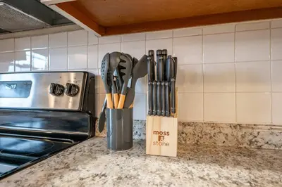 a knife block with utensils on a kitchen counter at The Terrace Timber House For 8 in Hamilton
