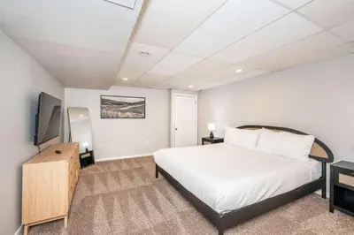 a bedroom with a large white bed and a television at The Terrace Timber House For 8 in Hamilton