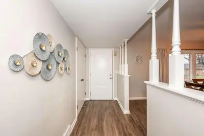 a hallway with white walls and a staircase with plates on the wall at The Terrace Timber House For 8 in Hamilton