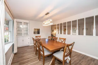 a dining room with a wooden table and chairs at The Terrace Timber House For 8 in Hamilton