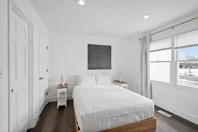 a white bedroom with a bed and a window at Nookside Grand Estate For 8 in Hamilton