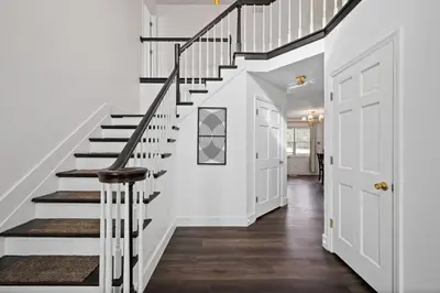 a staircase in a home with white walls and wood floors at Nookside Grand Estate For 8 in Hamilton