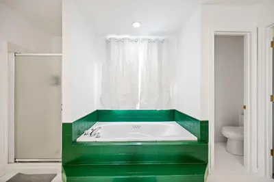 a green tub in a bathroom with a toilet at Nookside Grand Estate For 8 in Hamilton