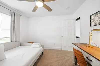 a white bedroom with a couch and a ceiling fan at Nookside Grand Estate For 8 in Hamilton