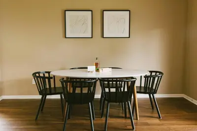a dining room table with chairs and two pictures on the wall at 