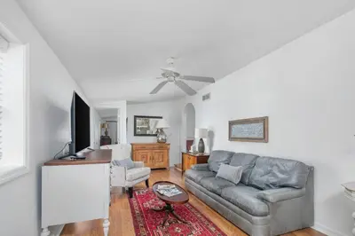 a living room with a couch and a flat screen tv at Charming Cottage | Near I-75 & Horse Park + Farms in Lexington