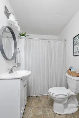 a bathroom with a toilet and a sink and a mirror at Charming Cottage | Near I-75 & Horse Park + Farms in Lexington